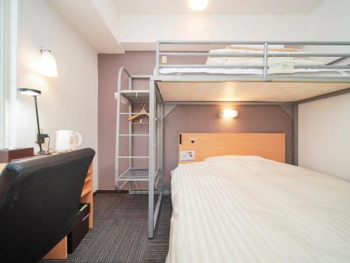 北九州小仓站南口超级酒店的一间卧室配有双层床和书桌