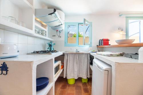 埃斯卡洛Xaloc的厨房配有白色的柜台和水槽