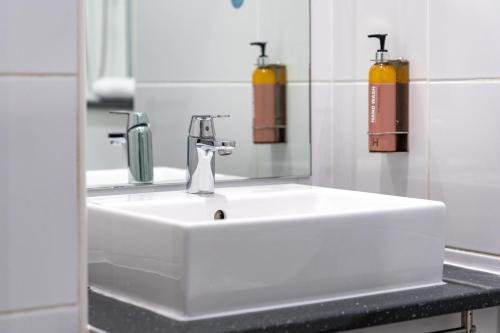 利物浦Heeton Concept Hotel - City Centre Liverpool的浴室设有白色水槽和镜子