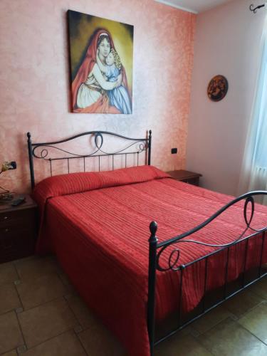 罗通达B&B Cuoreverde Pollino的卧室配有红色的床,墙上挂有绘画作品