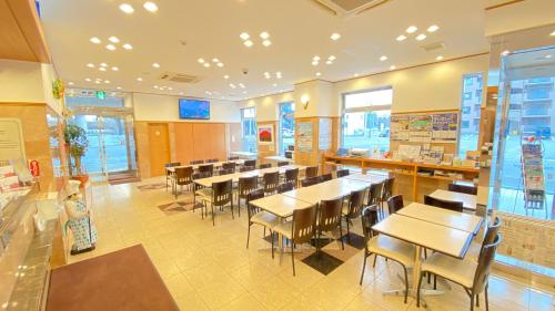 带广Toyoko Inn Hokkaido Tokachi Obihiro Ekimae的餐厅内带桌椅的用餐室