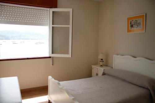 拉科萨Casa sobre o mar A Ceboleira的卧室配有白色的床和窗户。