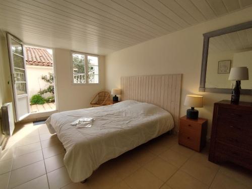 奥雷龙圣乔治Maison Pimpino face à la plage的一间卧室设有一张大床和两个窗户。