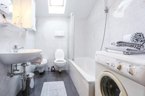 丘萨Moarhof Gufidaun的白色的浴室设有洗衣机和水槽。