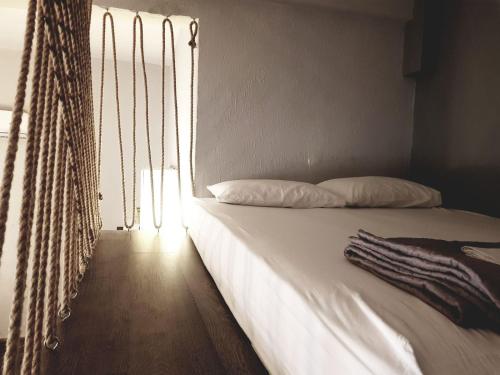 奥马斯帕纳吉亚斯Loft house 2的窗户客房内的一张带白色床单的床