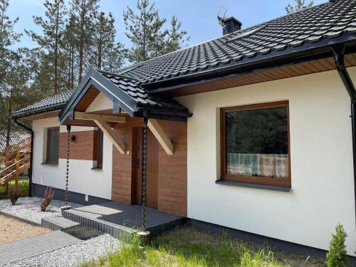 PłaskaAgroturystyka Dom turystyczny Chomiczówka的一间黑色屋顶的小房子