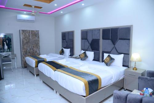 拉合尔GO Luxury Grand Hotel的一间大卧室,配有两张床和一张桌子