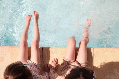 马雷讷INSPIRE Villages - Marennes Oléron的两个女人躺在游泳池边