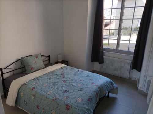 萨兰莱班O'Couvent - Appartement 91 m2 - 4 chambres - A521的一间卧室配有一张带蓝色被子的床和一扇窗户