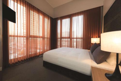 柏林阿迪娜柏林查理检查站公寓酒店的一间卧室设有一张床和大窗户