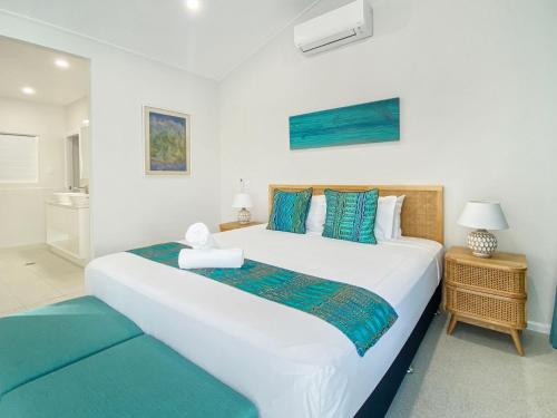 Picnic BayRock Salt Villa 1的卧室配有带蓝色枕头的大型白色床