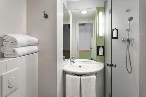 萨拉戈萨B&B HOTEL Zaragoza Plaza Mozart的白色的浴室设有水槽和淋浴。