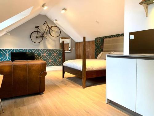 剑桥Scholar's Loft - Cosy & Close to Central Cambridge的卧室配有一张床,墙上挂着自行车