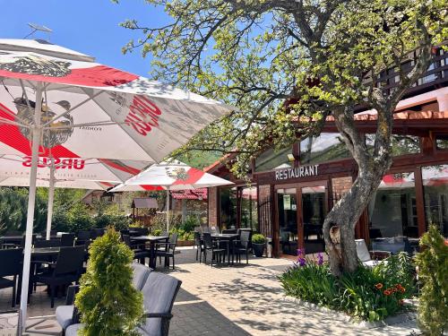 布朗Casa Cenţiu的餐厅前方设有带桌子和遮阳伞的庭院。