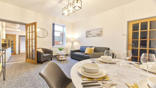 BedlingtonHost & Stay - Millbank Crescent Apartments的客厅配有桌子和沙发