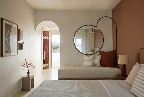 斯派赛斯Yayaki Spetses的卧室配有一张壁挂镜子的床