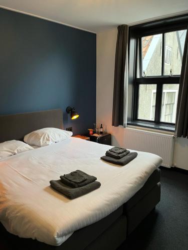 弗拉讷克道伦咖啡馆酒店的一间卧室配有一张床,上面有两条毛巾
