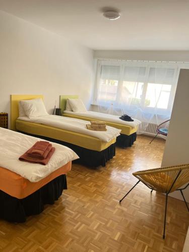 洛迦诺Casa Kromatica的带三张床和椅子的房间