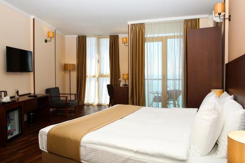 巴统考内尔酒店的酒店客房设有一张大床和一张书桌。