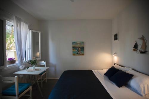 圣安娜纳克索斯Skypiea Room的一间卧室配有一张床、一张桌子和一个窗户。