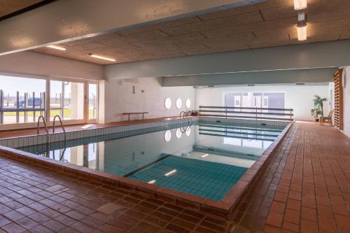 韦斯特维Agger Holidays的大型室内游泳池,铺有瓷砖地板