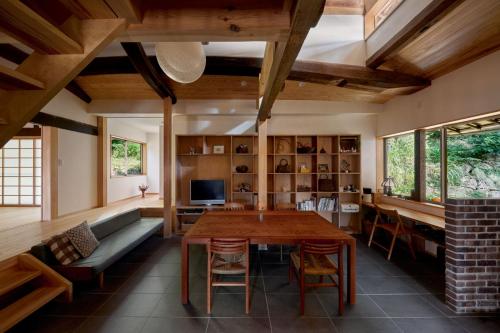 AkaiwaCasa KitsuneAna The Satoyama experience in a Japanese-style modernized 100-year-old farmhouse的客厅配有木桌和沙发