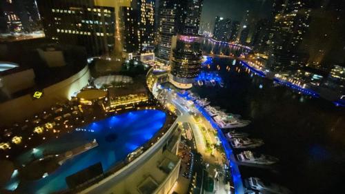 迪拜The Address Dubai Marina的夜间的城市空中景观,有船