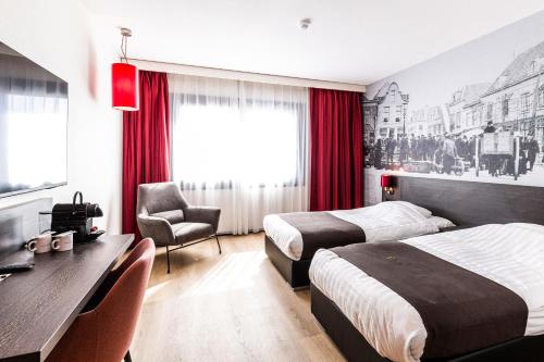 阿默斯福特Bastion Hotel Amersfoort的酒店客房配有两张床和一张书桌