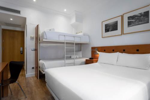 马德里珀蒂宫赛珀格兰维尔酒店的卧室配有一张白色的大床和双层床。