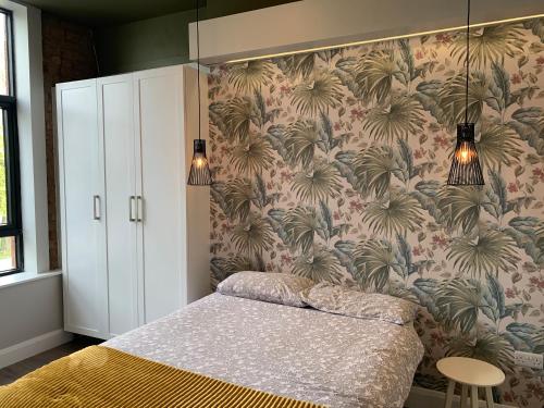 邓多克Clanbrassill loft的一间卧室配有一张带花卉壁纸的床
