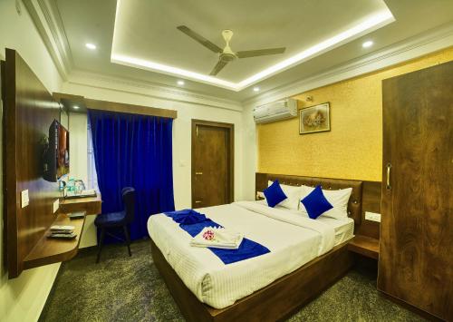 班加罗尔SM Royal Stay Hotel - Near Bangalore international Airport的酒店客房带一张床铺、一张书桌和一间卧室