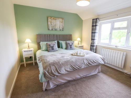 根斯堡6 Hillside Cottages的一间卧室设有一张带绿色墙壁的大床