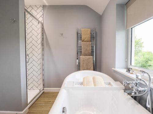 根斯堡6 Hillside Cottages的带窗户的浴室内的白色浴缸
