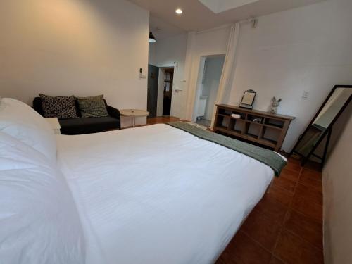 太麻里马鲁大民宿的卧室配有一张白色的大床和一张沙发。
