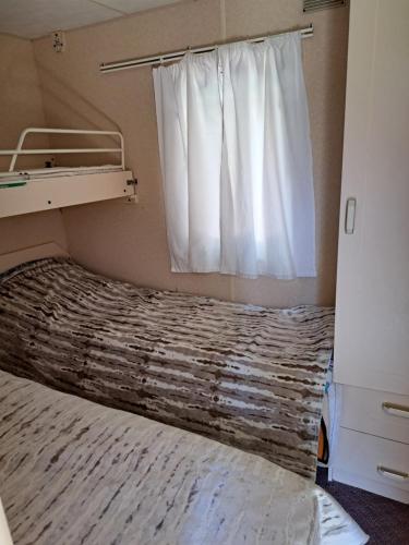 尼察Lini Guest House的一间卧室配有一张带窗帘的床和窗户