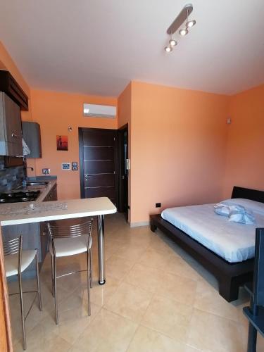 陶里萨诺Gagliardo House的一间卧室配有一张床,厨房配有桌子