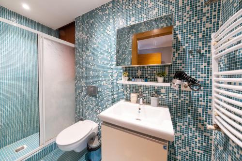 伊斯坦布尔King Suites Beşiktaş的一间带水槽、卫生间和镜子的浴室