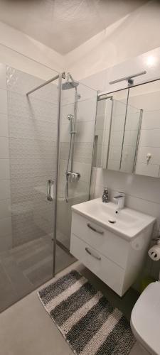 萨利Apartments Orlić的浴室配有白色水槽和淋浴。