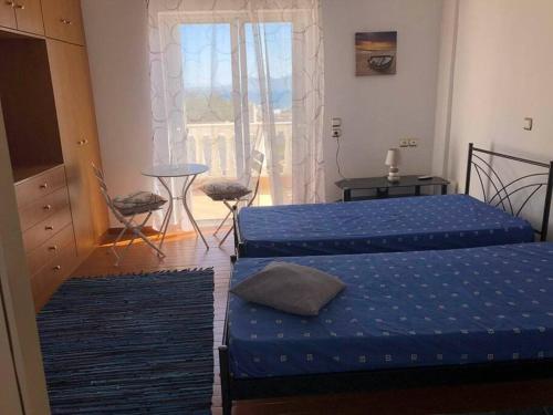 迈加洛丘里Nikolas house的带窗户的客房内的两张床和蓝色床单