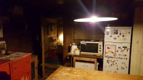 Ciernes-PicatL'Étoile Enchantée的厨房配有冰箱、桌子和灯