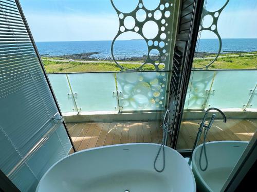 西归浦市Seopjikoji Oceanview Apartment的一间带两个水槽的浴室,享有海景