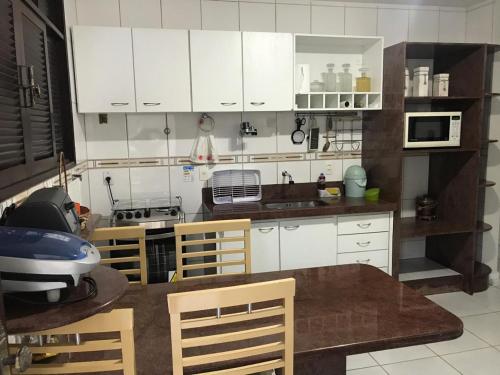 纳塔尔Excelente casa 300m2 em Bairro Nobre perto de tudo的厨房配有白色橱柜和桌椅