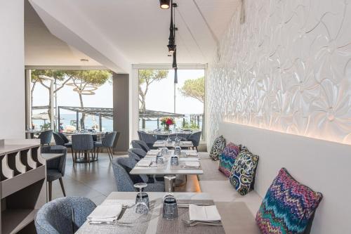 普拉加德阿罗Hotel Planamar by Escampa Hotels的用餐室设有桌椅和窗户。