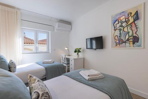 卡斯卡伊斯Gia's Homes Cascais by LovelyStay的白色的客房设有两张床和窗户。
