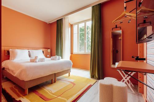 奥尔良La Loge Gogaille - Fernand Rabier - accès autonome的一间卧室设有橙色的墙壁、一张床和电视