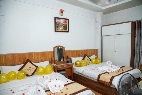 河内HOTTEL PHƯƠNG ĐÔNG的酒店客房设有两张带黄色气球的床。