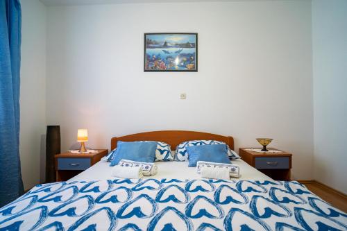 尼亚卢卡Sunny的一间卧室配有一张带蓝色和白色棉被的床