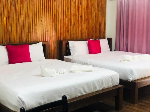 Ban Ton Liangกอบสุข รีสอร์ท2 k04的配有红色和白色枕头的客房内的两张床
