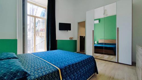 卡塔尼亚DUHOME apartment in the heart of Catania的一间卧室配有蓝色的床和镜子