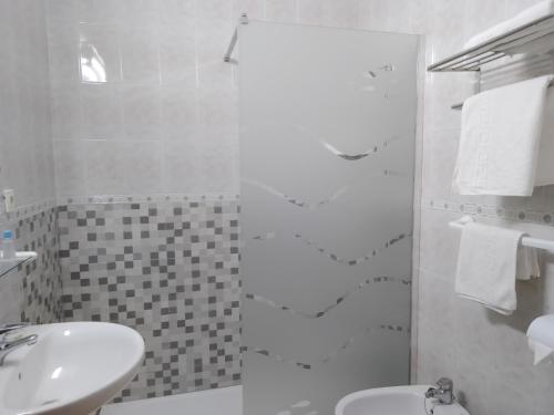 奇皮奥纳洛斯阿科斯旅舍的白色的浴室设有水槽和淋浴。